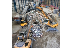 Image Three crains inside a recycling facility.